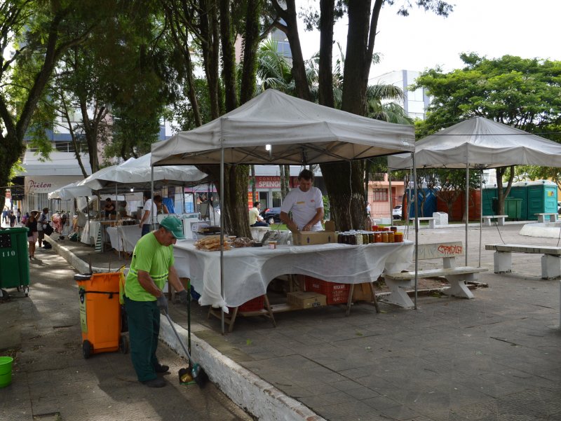 Comerciantes da feira de produtos coloniais dividem o espaço com equipes de limpeza da Prefeitura (Foto: João Alves)