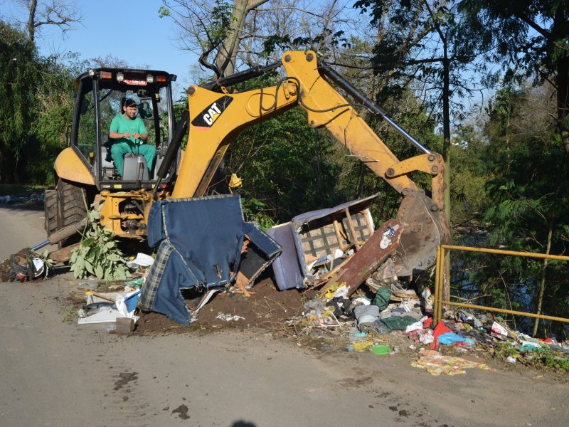 Com o auxílio de uma retroescavadeira, foi retirada grande quantidade de lixo doméstico na Rua  Anselmo Saldanha Zoch  (Foto: João Alves)